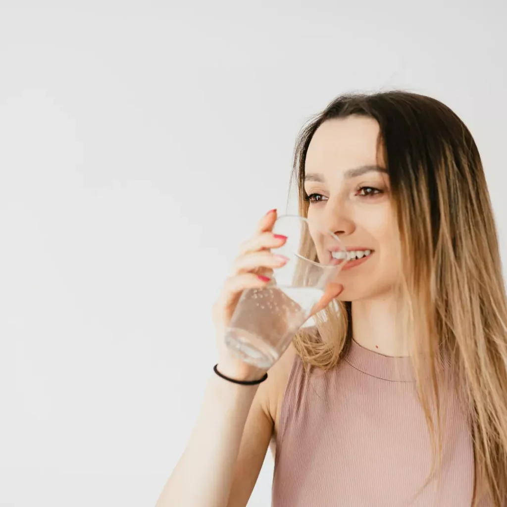 Foto de una persona bebiendo agua con una expresión satisfecha.